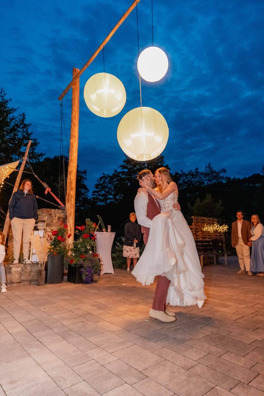 Tanzendes Brautpaar unter großen Laternen