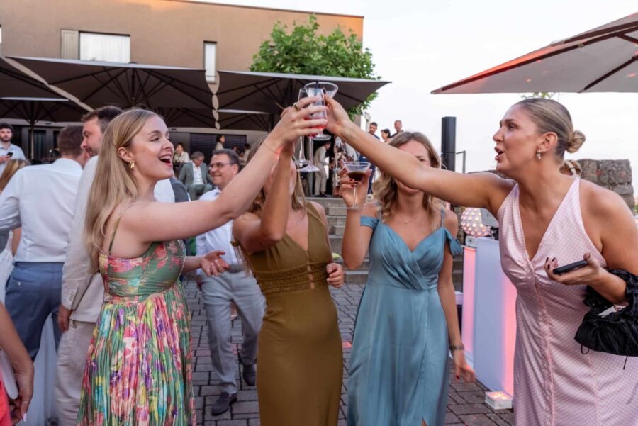 Hochzeit Steinburg Würzburg | Editorial Style & Party | Florian Knusper 74 Gäste stoßen mit Getränken während Hochzeitsempfang an