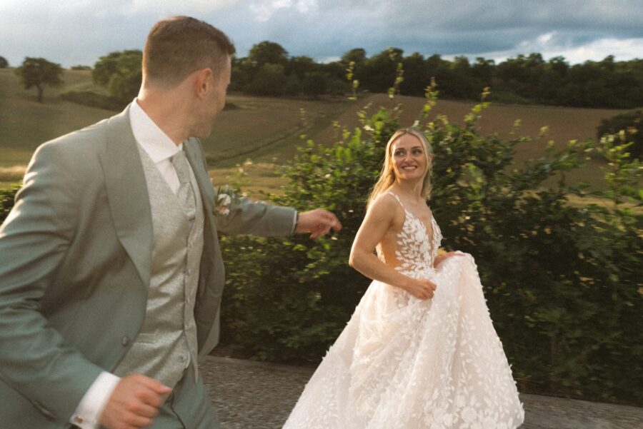 Brautpaar tanzt im Grünen bei Sonnenuntergang