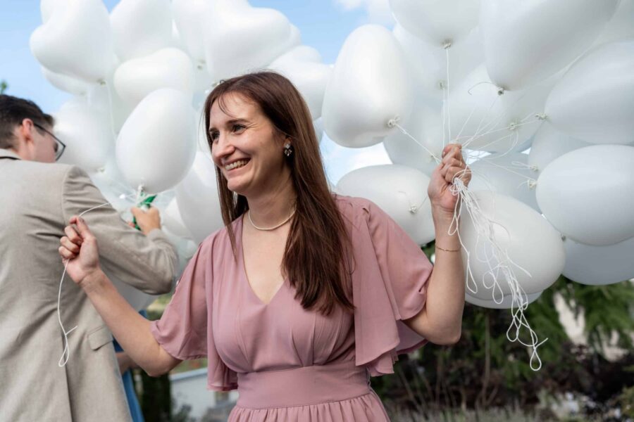 Hochzeit Villa Oriental | Editorial Summer Vibes & Live Cooking 461 Frau mit Herzluftballons bei Hochzeitsempfang