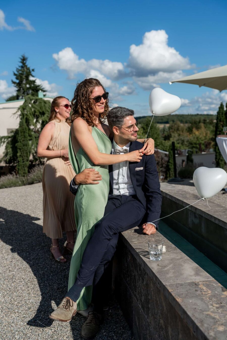 Gäste mit Herzballons im Garten bei Sonnenschein