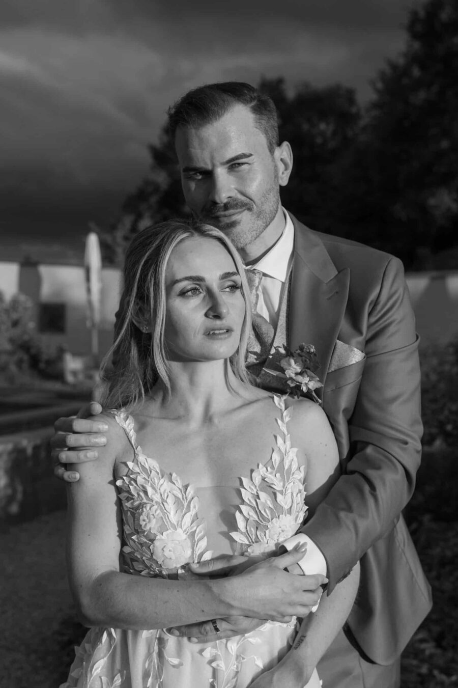 Brautpaar umarmt sich im Garten bei Sonnenuntergang