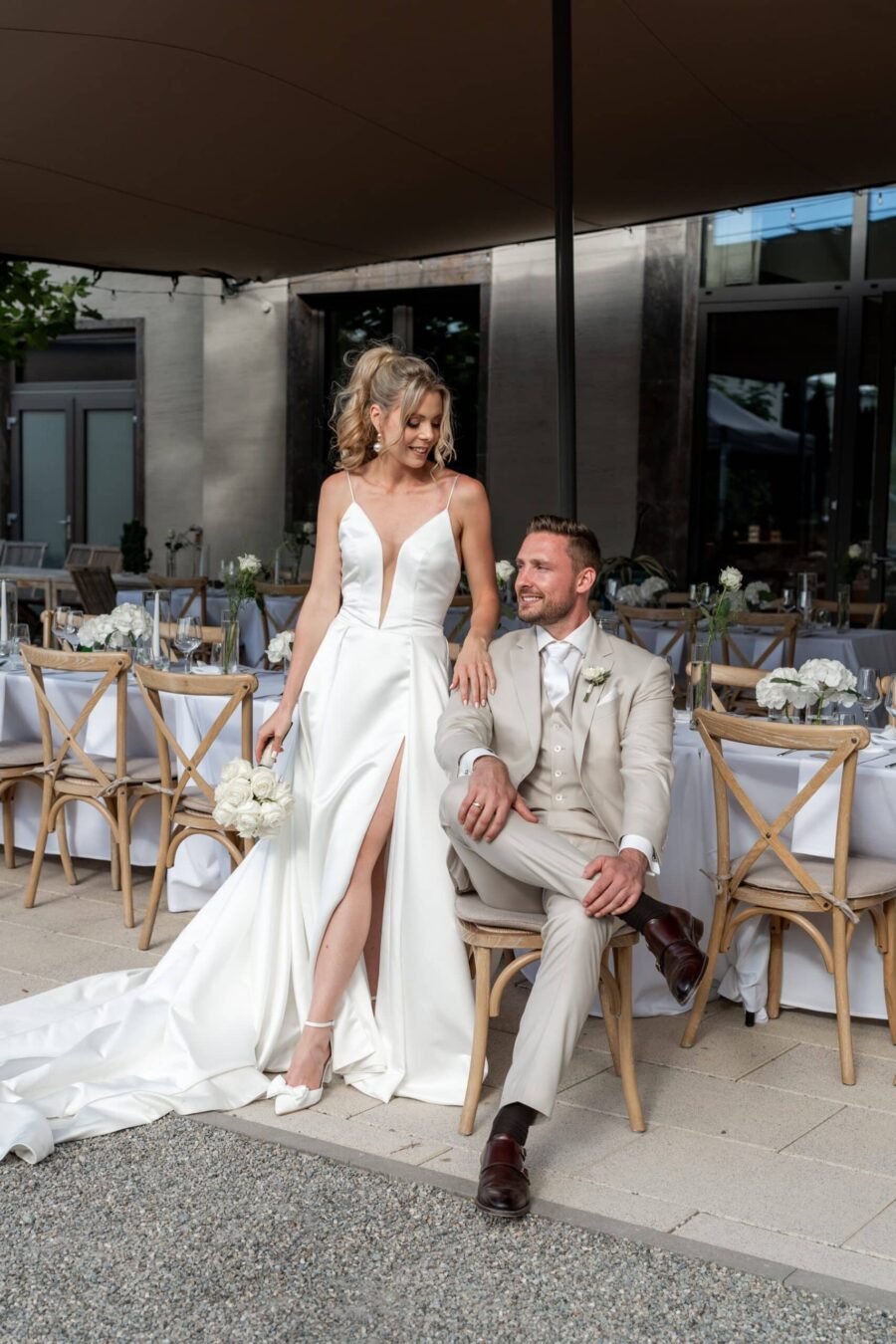 Hochzeit Villa Oriental | Editorial Summer Vibes & Live Cooking 197 Brautpaar elegant vor gedeckter Tafel im Freien