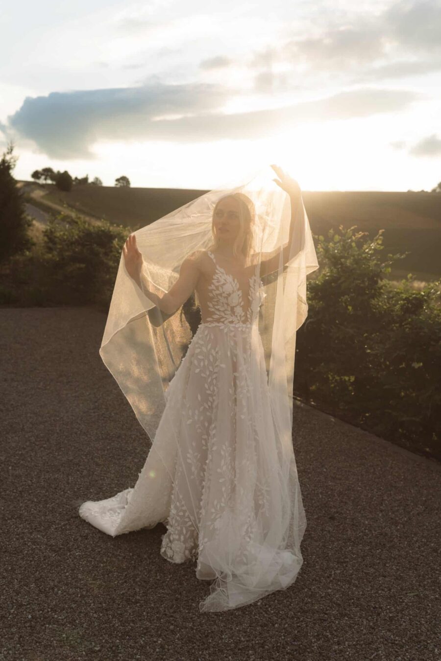 Braut mit Schleier bei Sonnenuntergang im Freien