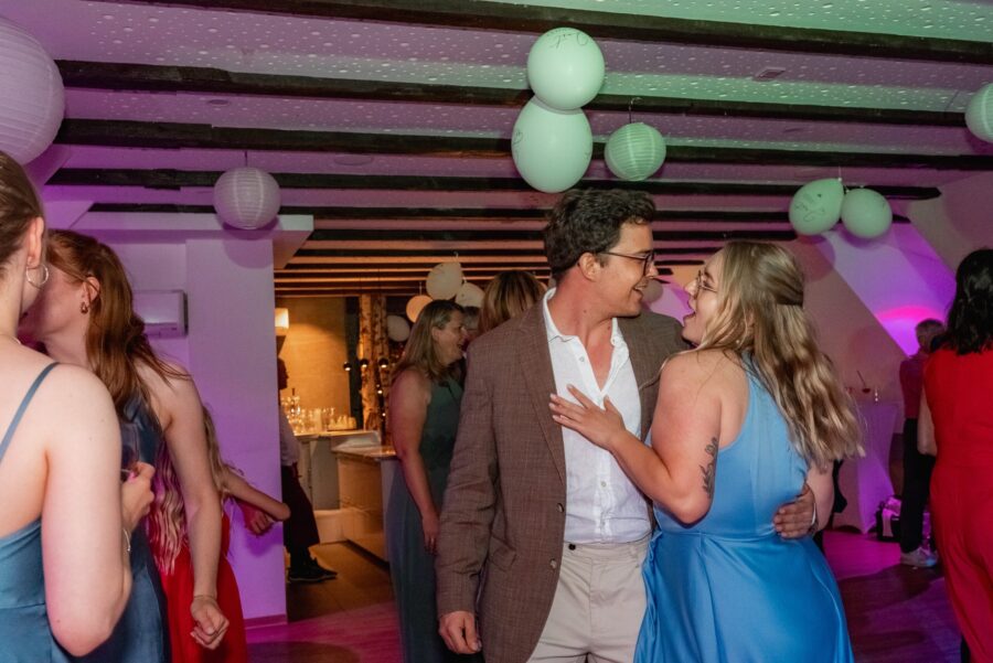 Hochzeitsgäste tanzen in festlich dekorierter Location