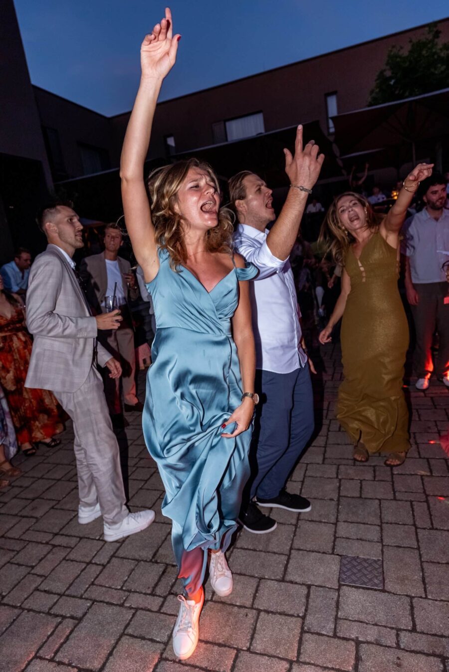 Hochzeitsgäste tanzen ausgelassen im Freien.