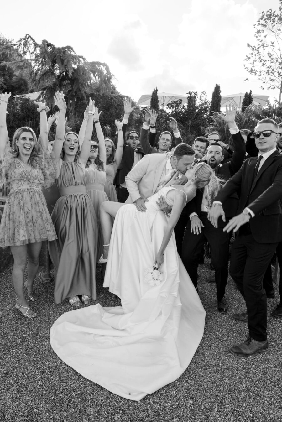 Brautpaar küsst sich vor jubelnden Hochzeitsgästen