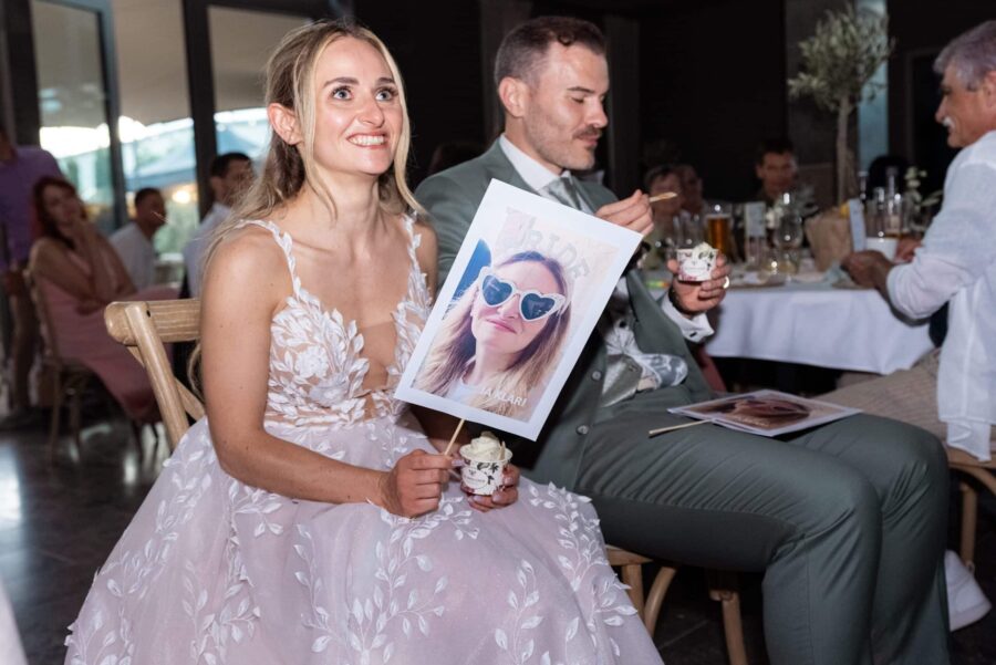 Brautpaar lacht bei Hochzeitsspiel am Tisch.