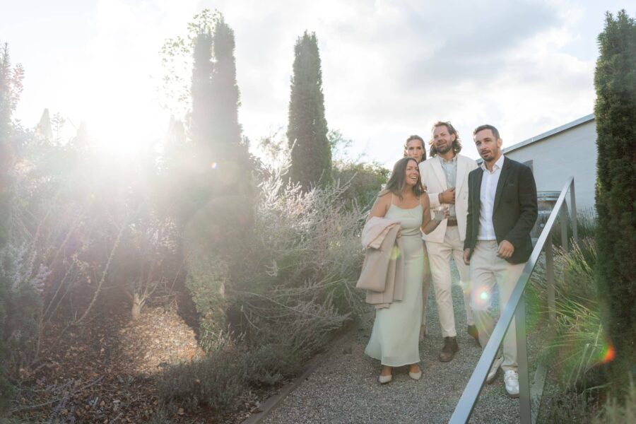 Gäste auf Hochzeitsfeier im sonnigen Gartenweg