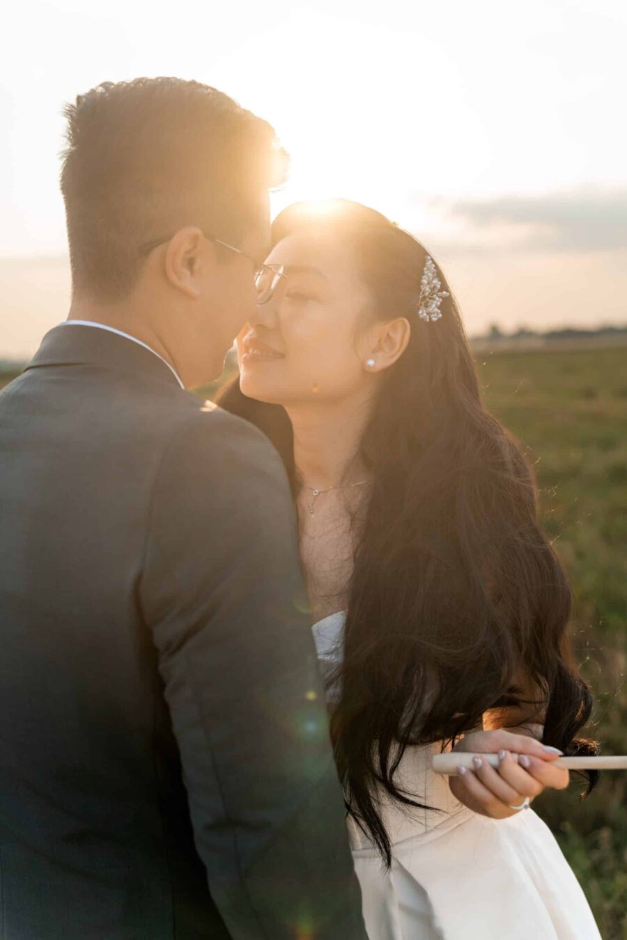 Brautpaar lächelt sich bei Sonnenuntergang an.