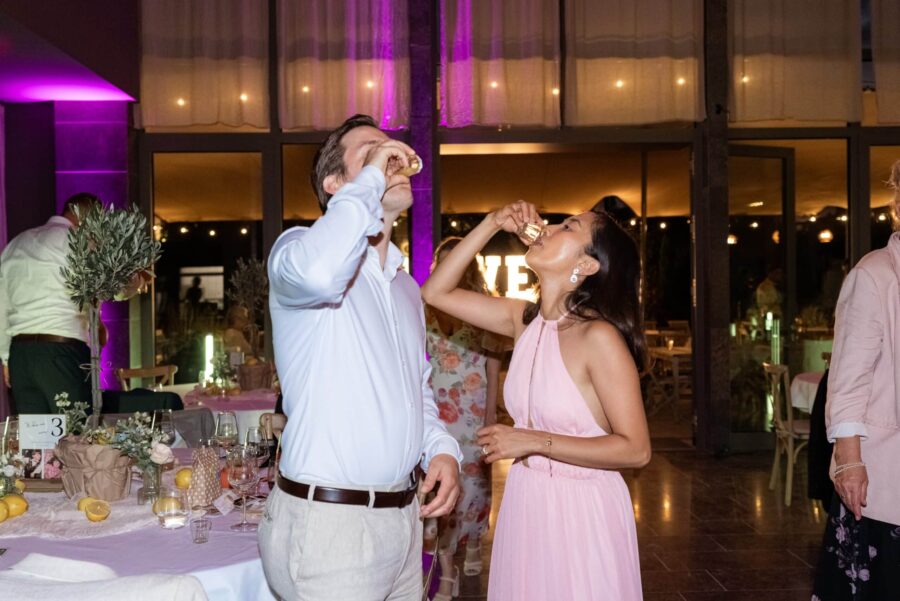 Gäste trinken Hochzeits-Shots bei Abendfeier