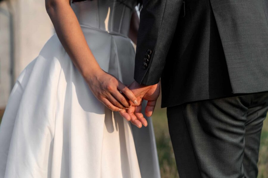 Brautpaar hält Händchen im Sonnenschein