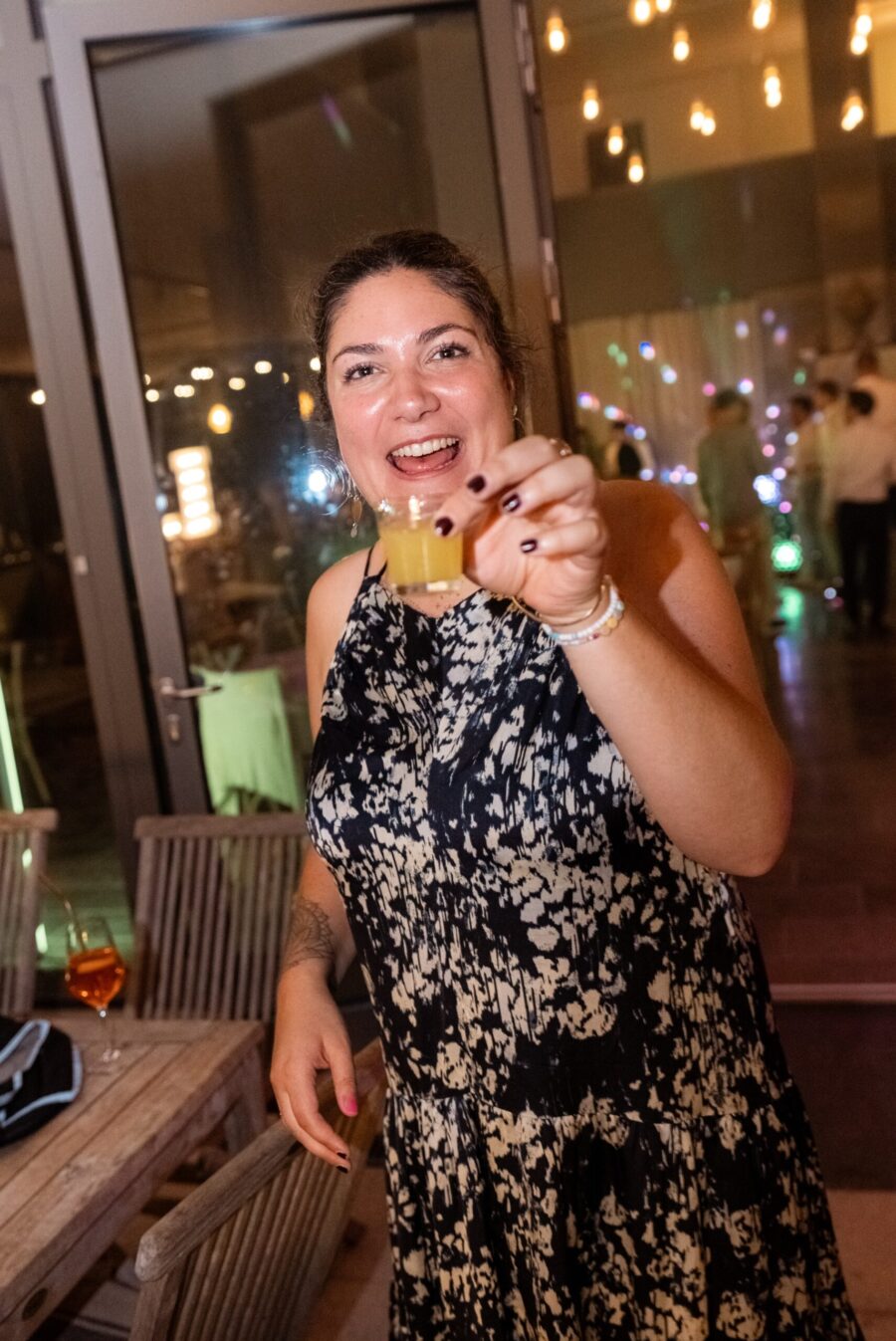 Eine Frau mit Getränk auf Hochzeitsfeier.