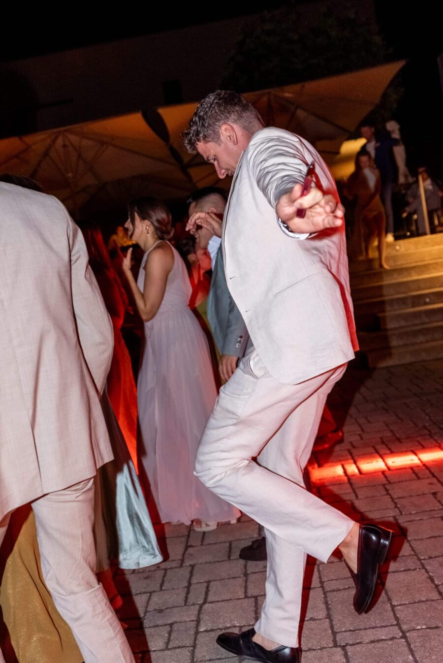 Tanzende Gäste bei Abendhochzeit im Freien