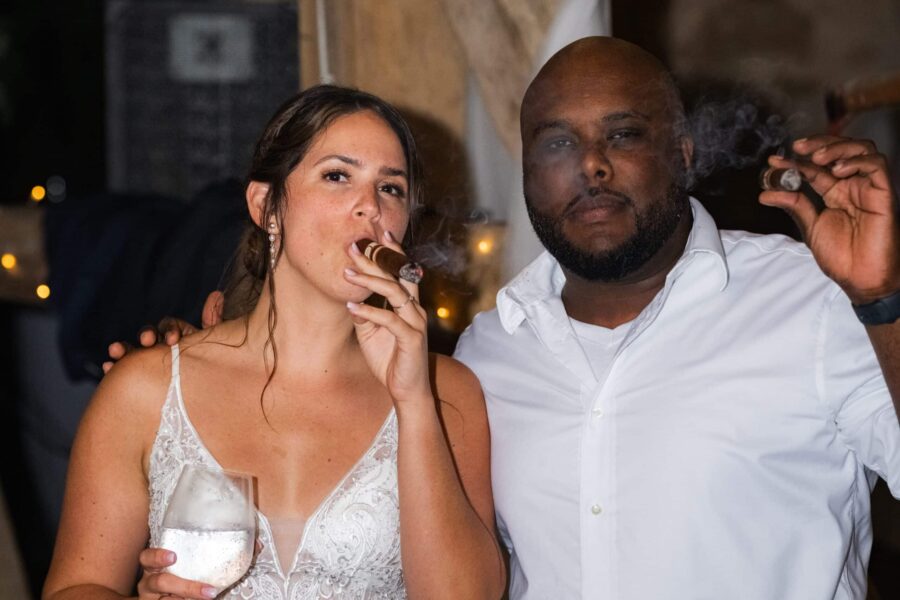 Brautpaar raucht Zigarren bei Hochzeitsempfang