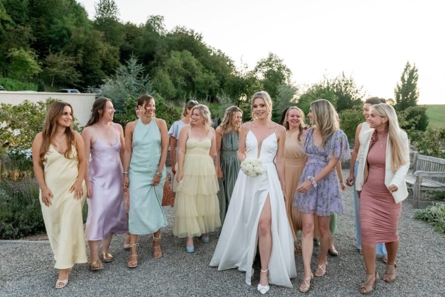 Braut und Brautjungfern im Garten spazieren
