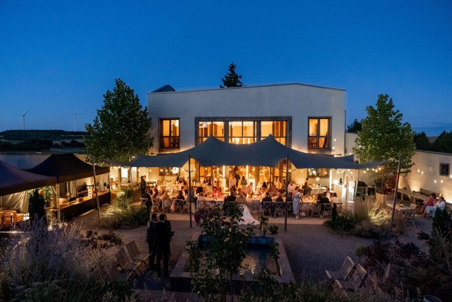 Hochzeitsfeier im Garten unter Lichterketten bei Nacht