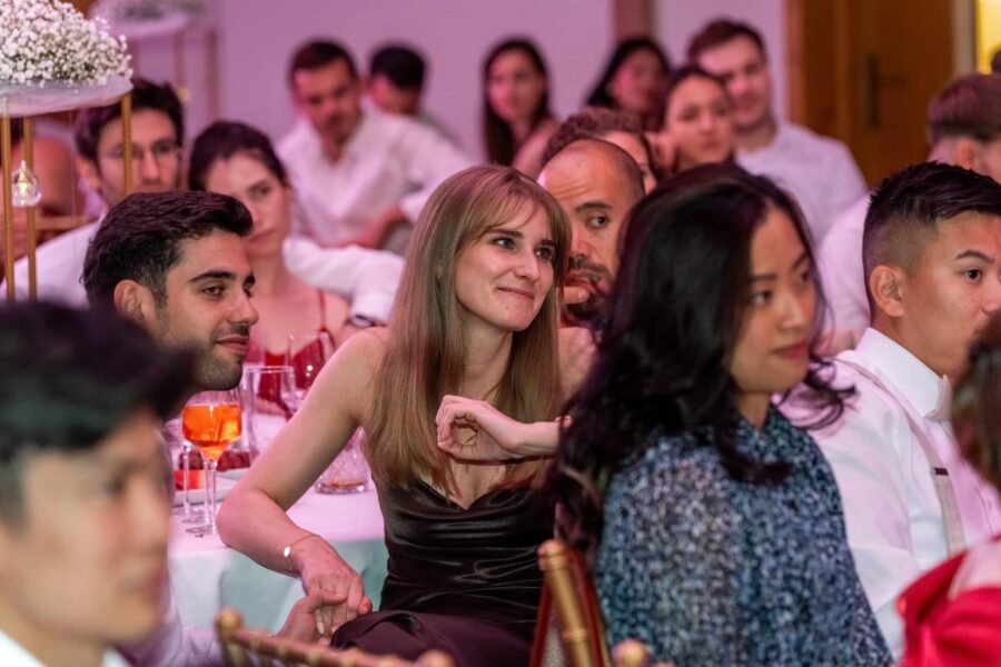 Hochzeitsgäste sitzen an gedeckten Tischen.