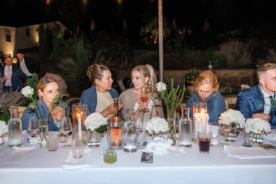 Hochzeitsgäste am festlich gedeckten Tisch im Freien