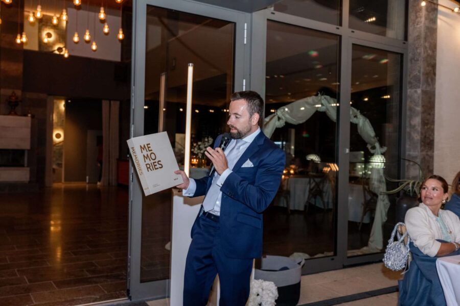 Mann mit Mikrofon bei Hochzeitsrede in Festsaal