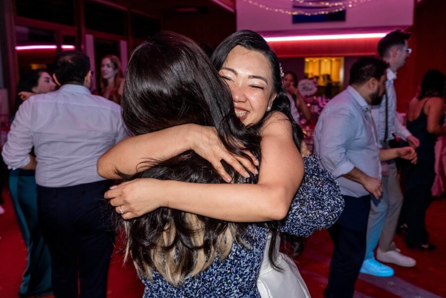 Umarmung beim Hochzeitstanz in stimmungsvoll beleuchtetem Saal