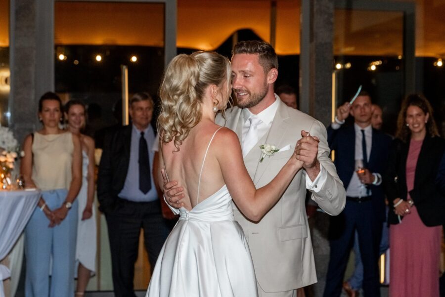 Brautpaar beim Hochzeitstanz, umgeben von Gästen