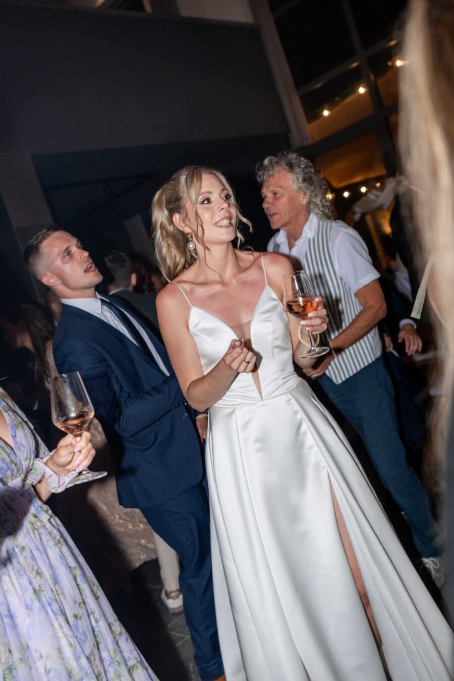 Hochzeitsgäste feiern mit Weingläsern bei Abendempfang