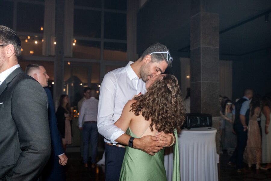 Paar tanzt küssend auf Hochzeitsfeier im Innenbereich